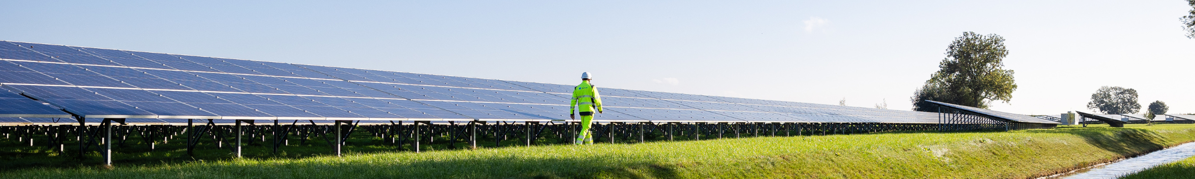 Um homem caminhando em um parque solar